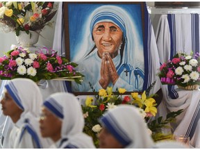 Indian Nuns from the Catholic Order of the Missionaries of Charity watch the live telecast of the canonisation of Mother Teresa from Rome, at the Mother House in Kolkata on September 4, 2016. Singing nuns and followers clutching flowers flocked to Mother Teresa's tomb in the Indian city of Kolkata to celebrate her proclamation as a saint at the Vatican People started gathering from early morning at Mother House in Kolkata for a special mass for the "Saint of the Gutters" ahead of the ceremony due at St Peter's Basilica.    /