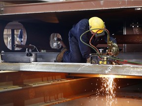 A worker cut a piece of steel for the Asterix (Resolve Project) boat at the Davie Shipyard in Levis on Monday September 12, 2016.