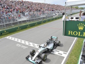 Mercedes driver Lewis Hamilton of Britain crosses the finish line to take the checkered flag and win the Canadian Grand Prix in Montreal on Sunday, June 7, 2015.