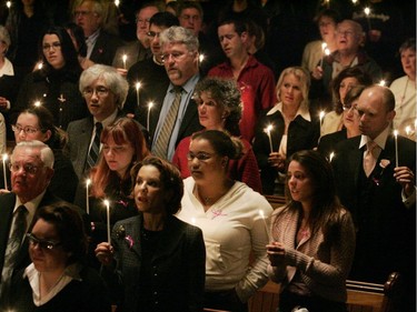 Members of Dawson College's extended family hold candles and sing at the end of "an evening of healing, sharing and moving forward" at St. James United Church, Sept. 20, 2006.