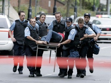 Montreal police use a small table to carry out a victim after the shooting rampage at Dawson College, Sept. 13, 2006.