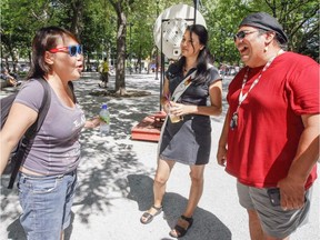 Community workers Nakuset, centre, and Tim Armstrong, right, speak with Connie Kadlutsiak at Cabot Square. Kadlutsiak left Nunavut 16 years ago. The workers are part of the Cabot Square Project.