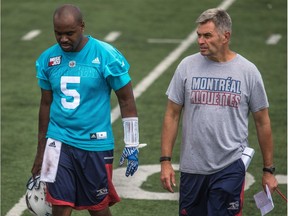 Recently promoted Montreal Alouettes head coach Jacques Chapdelaine leaves practice field with former quarterback Kevin Glenn at Stade Hébert on Aug. 17, 2016.