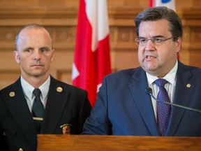 Montreal mayor Denis Coderre, right, speaks to the media along with François Massé, left, chief of the Montreal fire department, at Montreal city hall on Friday, August 29, 2014 in reaction to the charges and disciplinary actions laid against some of the municipal workers who participated in the August 18th protest at at Montreal city hall.