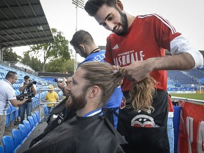 Montreal Impact head athletic trainer Nicolas Nault gets his head shaved as part of the Leucan Shaved Head Challenge during the Childhood Cancer Awareness Month in Montreal on Sept. 14, 2016