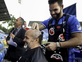 Montreal Impact owner Joey Saputo gets his head shaved as part of the Leucan Shaved Head Challenge during the Childhood Cancer Awareness Month in Montreal, on Wednesday Sept. 14, 2016.