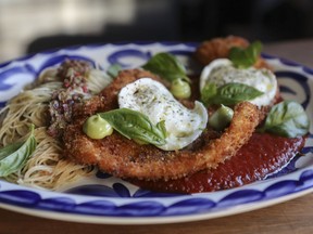 The chicken parmesan is a plate-sized chicken paillard, pan-fried to a golden crisp and topped with two rounds of fresh mozzarella, with a twirl of spaghettini and deep-red tomato sauce in the supporting roles.