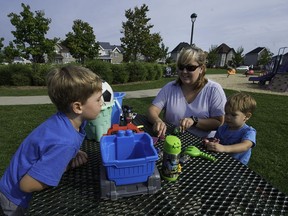 Nancy Côté plays with her children Vincent, left, and Justin, right, at Parc des Geraniums in Vaudreuil on Saturday, September 17, 2016. Côté has convinced the town to install bins in its parks and stock them with toys to play in the sand so that parents of young children do not have to lug the toys back and forth to the park. (Peter McCabe / MONTREAL GAZETTE)