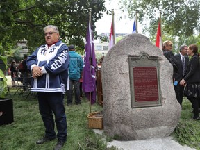 McGill professor Mike Loft stands next to the Hochelaga Rock, which has a new home with prominence, near the university's Roddick Gates on Sherbrooke St. W. A ceremony for it was held on Thursday. Loft is a Mohawk from Kahnawake.