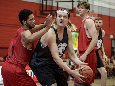 Win Butler of Arcade Fire goes for a shot against McGill University's Kendrick Jolin, left, during the POP vs. Jock charity basketball game at the McGill University Sports Centre on Saturday, Sept. 24, 2016, held as part of POP Montreal.
