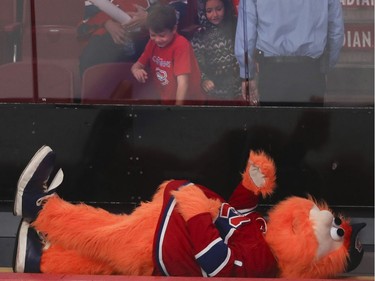 Youppi! amuses young fans while lying on a player's bench during a Red vs. White scrimmage with Montreal Canadiens players at the Bell Centre in Montreal Sunday, September 25, 2016.
