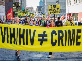 People hold a sign while walking on Ste-Catherine St. during the Ça Marche 2015 walk, the Farha Foundation.