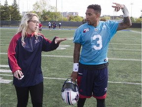 Montreal Alouettes Catherine Raiche, who is the team's coordinator of football administration, speaks with quarterback Vernon Adams Jr. following Alouettes practice on Wednesday September 28, 2016.