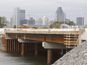 Workers in the final phase of construction on a new temporary bridge between Nun's Island and downtown Montreal on Monday, Sept. 29, 2014.