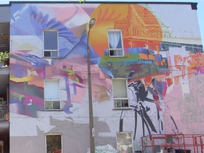 A mural being painted on a wall at the corner of Joliette St. and Ste-Catherine St. E. overlooking Edmond-Hamelin park.