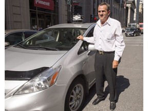 Taxi driver Mouhcine El Meliani stands beside his cab, Tuesday, Sept. 6, 2016 in Montreal.