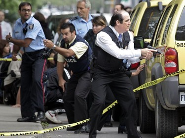 Police and public security personnel take cover behind some vehicles near Dawson College while responding to false reports of a second shooter in Westmount Square, Sept. 13, 2006.