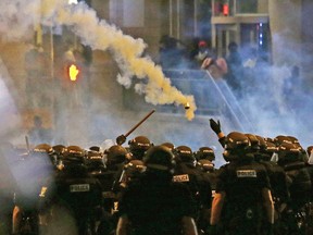 Police fire tear gas as protestors converge downtown following Tuesday's police shooting of Keith Lamont Scott in Charlotte, N.C., Wednesday, Sept. 21, 2016.
