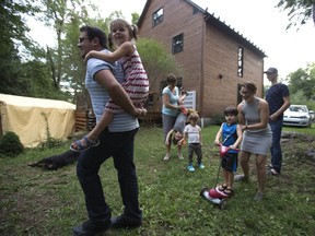 Two couples pooled their resources to buy a home, share expenses and daily tasks of raising family, play in the backyard of their new home. Loic Bisiere (left to right), with four-year-old Noomi, Jessica Dupont holding an upside down Elliot, Oona, four-year-old Loic gets a push from mom Alexandra Boisclair and Samuel Desrochers-Denault  in Ste-Sophie on September 13, 2016.   (Christinne Muschi / MONTREAL GAZETTE)