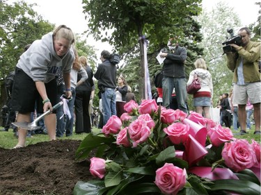 Shannon Pine puts compost around a just-planted tree dedicated to Anastasia De Sousa, at Dawson College on Sept. 13, 2007, during a ceremony on the anniversary the shooting spree which claimed the life of De Sousa also left 19 injured. The Japanese tree will bloom with pink flowers, De Sousa's favourite colour.