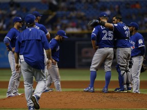 Pitcher Marco Estrada of the Toronto Blue Jays is comforted by catcher Dioner Navarro as manager John Gibbons comes out to take him off of the mound during the sixth inning of a game against the Tampa Bay Rays on Sept. 3, 2016, at Tropicana Field in St. Petersburg, Fla.
