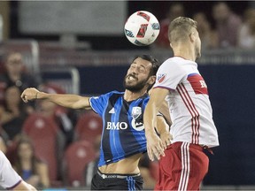 Toronto FC's Eriq Zavaleta and the Impact's Matteo Mancosu leap for ball at midfield during MLS soccer action in Toronto on Aug. 27, 2016.