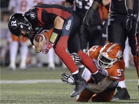 Ottawa Redblacks quarterback Trevor Harris (7) gets tackled by B.C. Lions' Alex Bazzie (53) during second half CFL action on Thursday, Aug. 25, 2016 in Ottawa.
