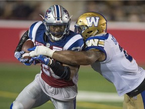 Montreal Alouettes running-back Tyrell Sutton is tackled by Winnipeg Blue Bombers linebacker Khalil Bass during fourth quarter CFL football action Friday, August 26, 2016 in Montreal.