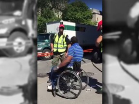A screengrab of a video that shows Montreal police officers harassing a man in a wheelchair.
