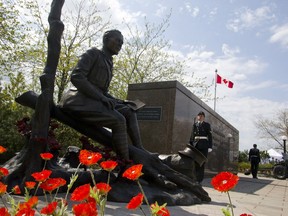 Poppies surround the newly unveiled statue of Lt.-Col. John McCrae to commemorate the Second Battle of Ypres and his poem In Flanders Fields during a ceremony in Ottawa on Sunday, May 3, 2015.