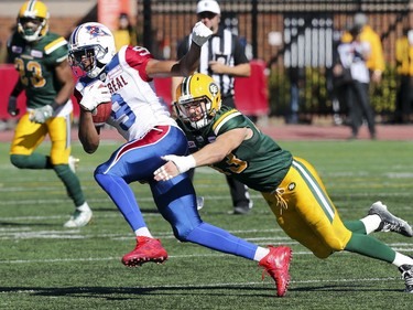 Montreal Alouettes' Kenny Stafford is tackled by Edmonton Eskimos' Neil King during CFL action at Molson Stadium in Montreal on Monday, Oct. 10, 2016.