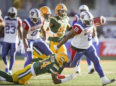 Montreal Alouettes' Nik Lewis breaks a tackle by Edmonton Eskimos' Garry Peters during CFL action at Molson Stadium in Montreal on Monday, Oct. 10, 2016.