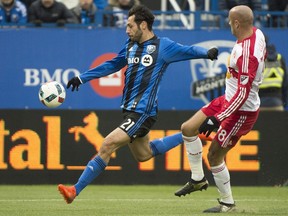 Impact's Matteo Mancosu, left, scores against the New York Red Bulls as Red Bulls' Aurelien Collin defends during second half action of the first leg of the eastern conference MLS soccer semifinal in Montreal on Sunday, Oct. 30, 2016.