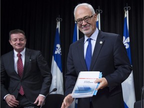 Quebec Finance Minister Carlos Leitao holds a copy of his economic update in October 2016.