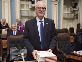Quebec Finance Minister Carlos Leitão holds a copy of his economic update moments before tabling it before question period, Tuesday, Oct. 25, 2016 at the legislature in Quebec City.