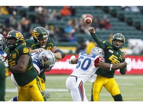 Edmonton's Mike Reilly (13) is tackled by Montreal's Henoc Muamba (50) during the first half of a CFL game between the Edmonton Eskimos and the Montreal Alouettes at Commonwealth Stadium in Edmonton, Alta.. on Sunday November 1, 2015. Ian Kucerak/Edmonton Sun/Postmedia Network