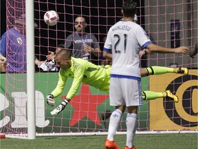 Montreal Impact goalkeeper Evan Bush, left dives at a shot that went wide of the goal in front of teammate Matteo Mancosu (21) during the second half of an MLS soccer game against Orlando City, Sunday, Oct. 2, 2016, in Orlando, Fla.