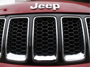 This file photo shows the Jeep logo on a Cherokee vehicle at a local car dealership in Tempe, Ariz. Jeep is recalling more than 228,000 SUVs worldwide to fix a software problem that can cause side air bags to inflate for no reason. The recall covers Jeep Cherokees from the 2014 and 2015 model years.
