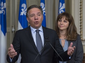 Coalition Avenir Québec Leader François Legault responds to reporters at a news conference at the entrance of a party caucus meeting, Thursday, October 27, 2016 at the legislature in Quebec City. CAQ MNA Nathalie Roy, right, looks on.