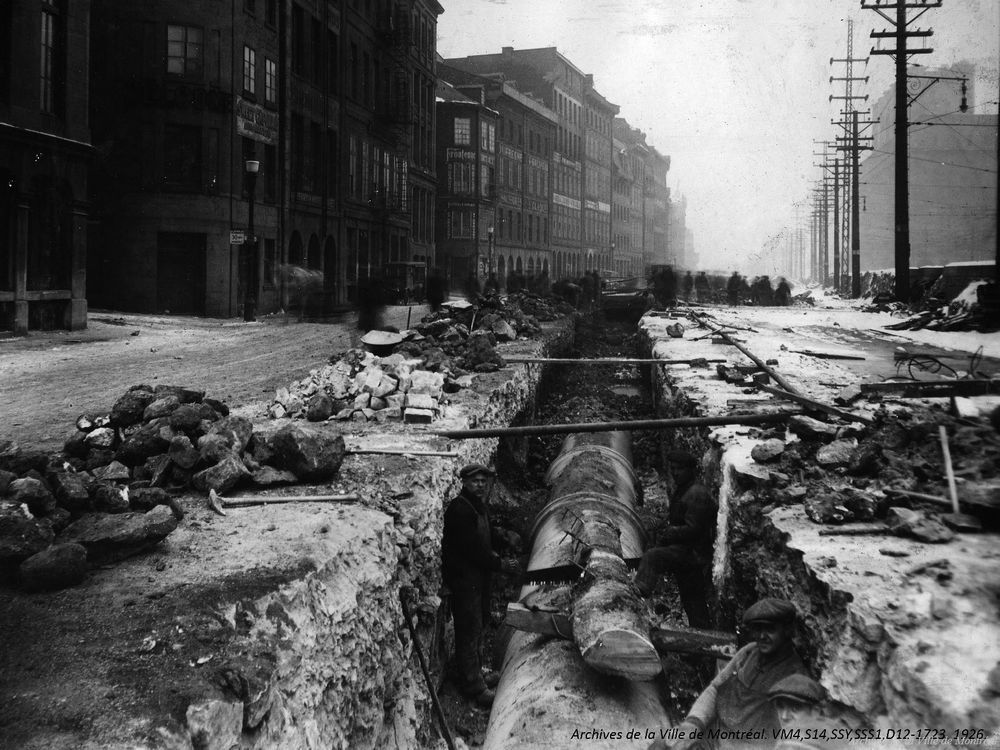 In 1926, workers install a water pipe under Commissioners St. (now known as de la Commune St.).