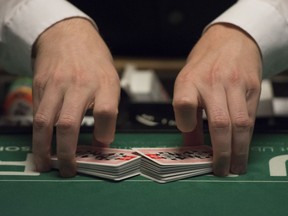 A dealer shuffles a deck of cards.