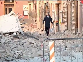 This handout TV grab released by Italian broadcast Sky Tg24 shows an Italian carabinieri walking on rubbles after an 6.6 magnitude earthquake on October 30, 2016 in Norcia. It came four days after quakes of 5.5 and 6.1 magnitude hit the same area and nine weeks after nearly 300 people died in an August 24 quake that devastated the tourist town of Amatrice at the peak of the holiday season. /