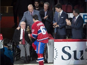 Montreal Canadiens captain Max Pacioretty is presented with the flame from Senator Jacques Demers during a pre-game torch ceremony for the team's home opener Tuesday, October 18, 2016 in Montreal. Looking on is Canadiens' head coach Michel Therrien and goaltender Carey Price.