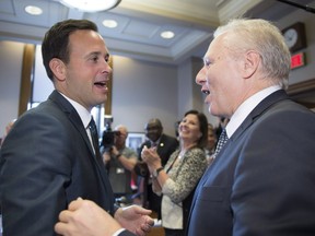 Newly elected Parti Quebecois leader Jean-Francois Lisee, right, is greeted by PQ MNA Alexandre Cloutier, during their first party caucus meeting at the National Assembly on Friday