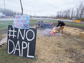 Teiorahkwathe Standup, left, and Blair Dearhouse camp out beside Hwy. 132 at the Mercier Bridge in Kahnawake Oct. 31, 2016. They are demonstrating in support of the Standing Rock anti-pipeline protest and say they plan to stay for as long as it takes.