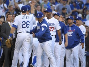 Los Angeles Dodgers manager Dave Roberts, second from left, celebrates with Chase Utley after the team's 6-5 win over the Washington Nationals during Game 4 of a baseball National League Division Series in Los Angeles, Tuesday, Oct. 11, 2016.