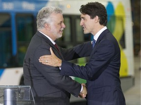 Quebec Premier Philippe Couillard, left, and Prime Minister Justin Trudeau, shake hands after signing documents in Montreal, on Tuesday July 5, 2016, that will see Ottawa invest more than $1.2 billion in transit and water treatment in Quebec during the next three years.