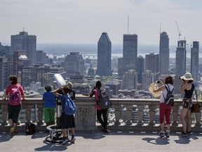 Tourists gather to look at the view of the Montreal city skyline from the Mount-Royal lookout in this file photo