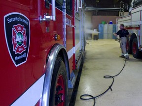 Montreal fireman Denis Lemay of Station 28 cleans his truck between calls at the east end fire station, in Montreal Thursday March 8, 2012.