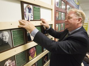 Kevin Figsby, organizer of the Point St-Charles Hall of Recognition, places the new inductees on the wall of The Pointe YMCA on Saturday, Oct. 1, 2016.